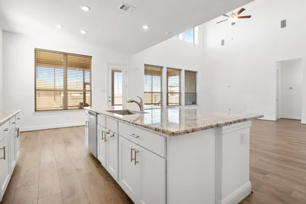 a spacious bathroom with a granite countertop sink a mirror and a bathtub