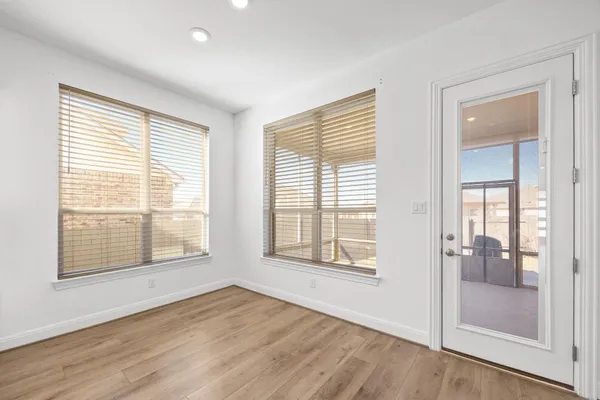 a view of an empty room with glass door and windows