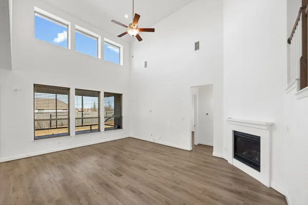 a view of an empty room with a fireplace and a window