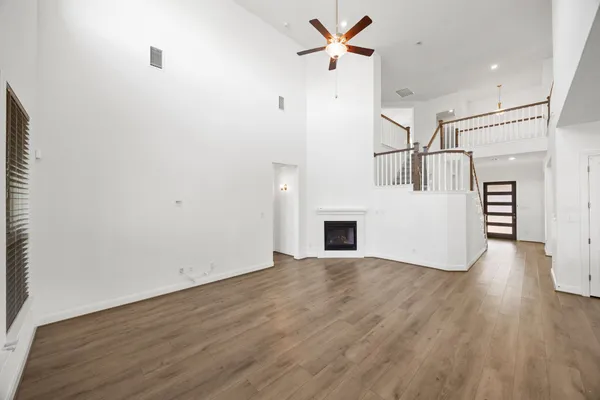 a view of empty room with wooden floor and fireplace