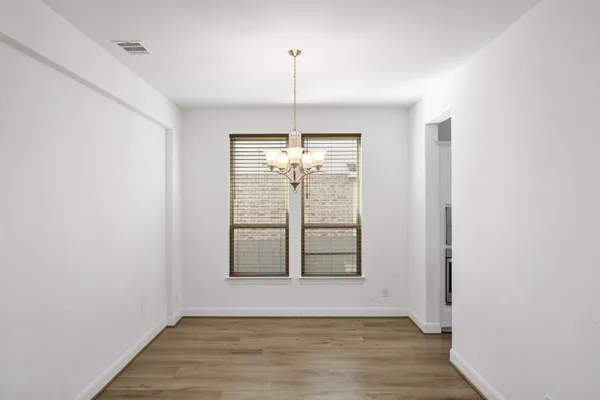 a view of a room with wooden floor and a ceiling fan