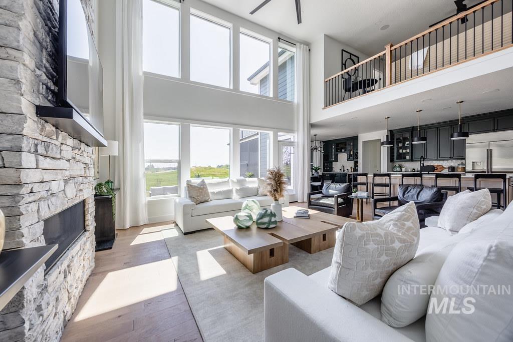7385 West Flathead Lk Street Eagle, ID 83616 - Photo 11 of 14 Living area featuring a towering ceiling, wood finished floors, and a stone fireplace