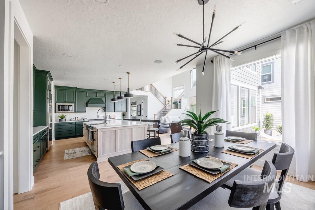 7385 West Flathead Lk Street Eagle, ID 83616 - Photo 13 of 14 Dining area featuring light wood-style flooring, stairway, a textured ceiling, and a chandelier