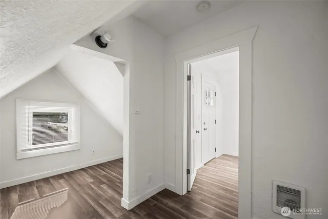 a view of a hallway with wooden floor and closet