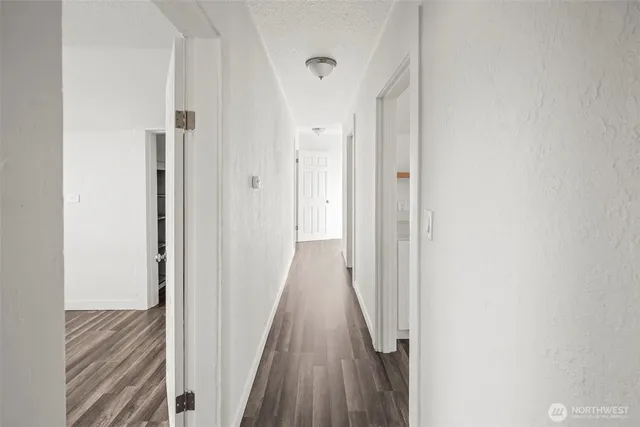 a view of a hallway with wooden floor
