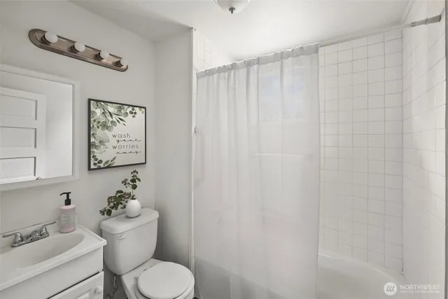 a bathroom with a toilet and a shower curtain
