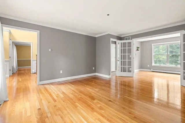 a view of empty room with wooden floor and fan