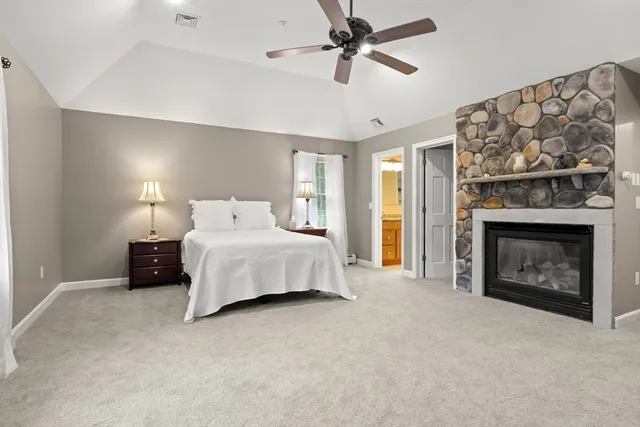 a spacious bedroom with a bed and a fireplace