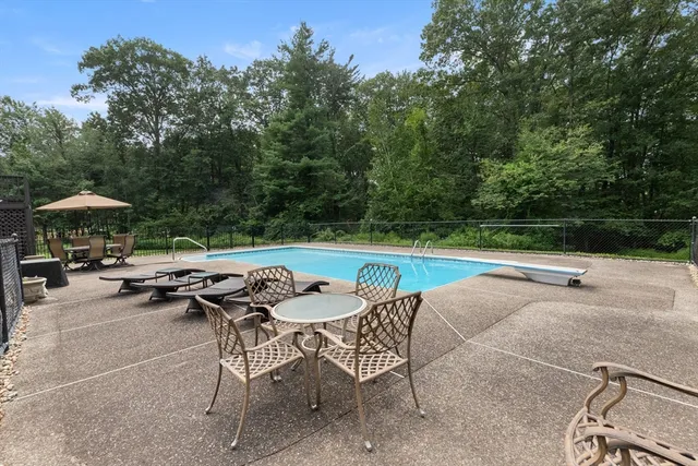 a view of backyard with swimming pool and outdoor seating