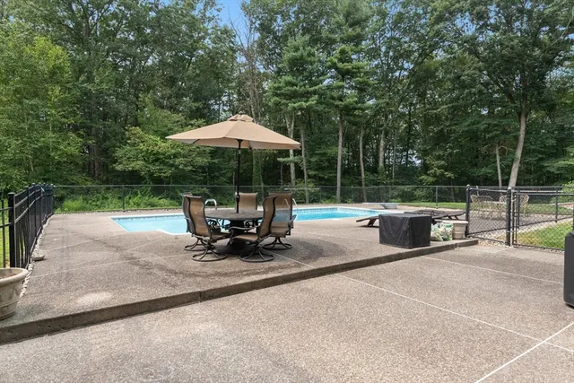 a view of backyard with a table and chairs under an umbrella