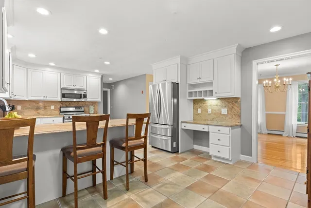 a kitchen with stainless steel appliances a stove a sink a oven a dining table and chairs
