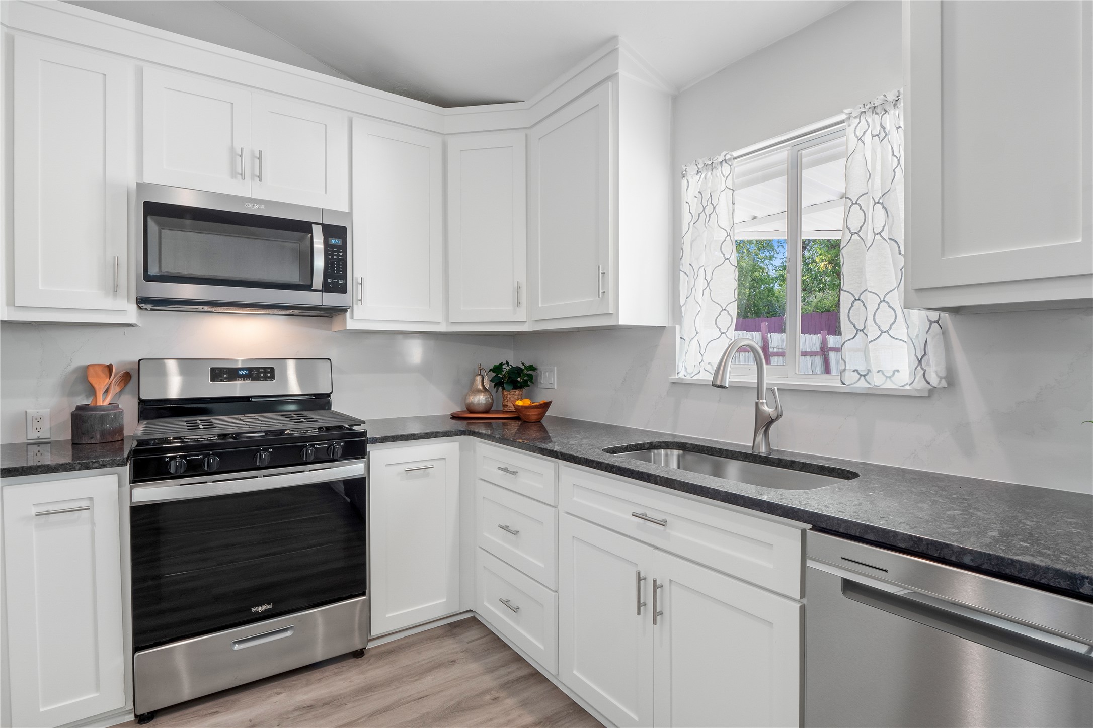 Upgraded kitchen with soft-close cabinetry, granite counters, stainless appliances, and smart storage including dual Lazy Susans.