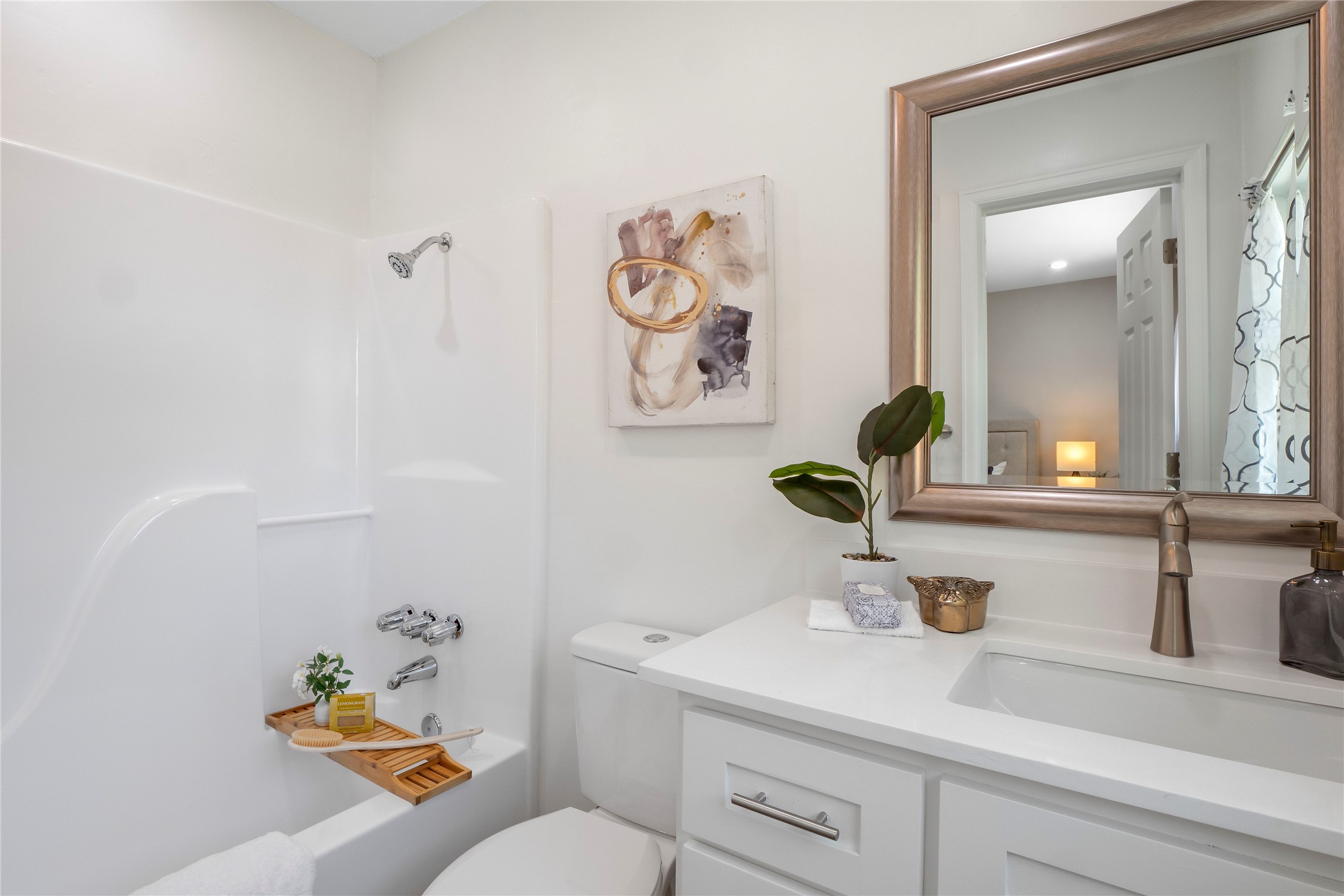8007 Colony Loop Drive Austin, TX 78724 - Photo 17 of 40 En suite bath with window, quartz vanity, and clean white shower-tub combo for a fresh, modern feel.