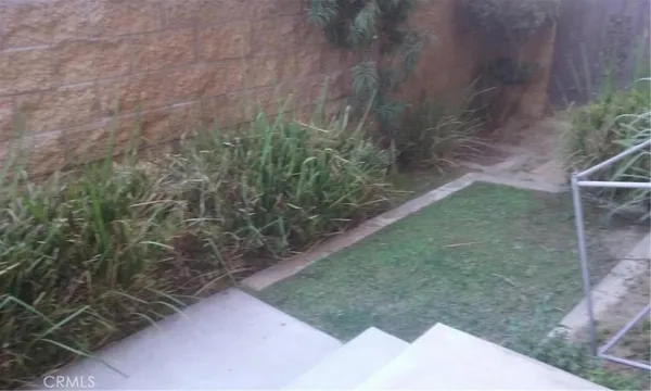 a view of a pathway that has potted plants