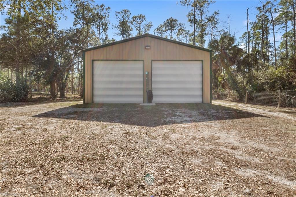 220 18th Avenue Northwest Naples, FL 34120 - Photo 15 of 18 a front view of a house with a yard and garage