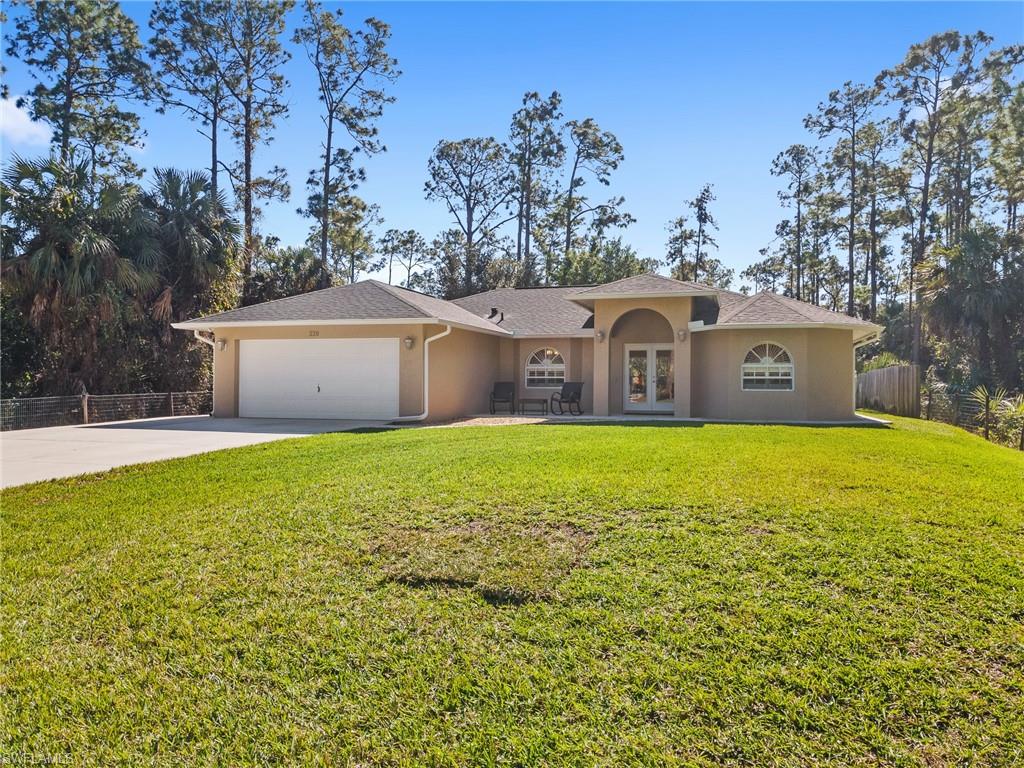 220 18th Avenue Northwest Naples, FL 34120 - Photo 4 of 18 a front view of a house with garden