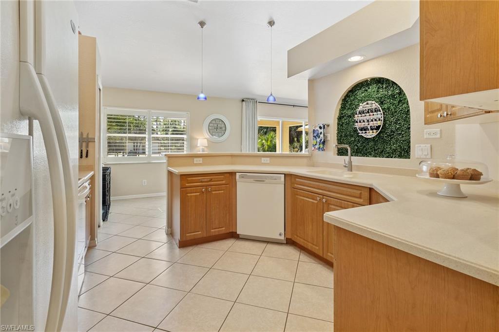220 18th Avenue Northwest Naples, FL 34120 - Photo 7 of 18 a kitchen with a sink a stove and a refrigerator
