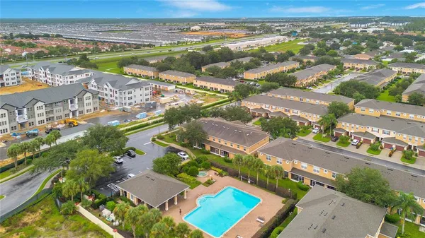 an aerial view of a city with lots of residential buildings ocean and mountain view in back
