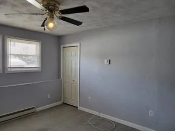 an empty room with windows and fan