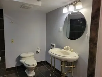 a bathroom with a toilet sink and mirror