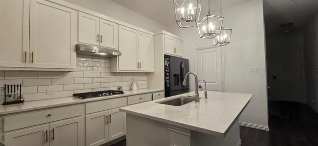 a kitchen with stainless steel appliances a sink a stove and refrigerator