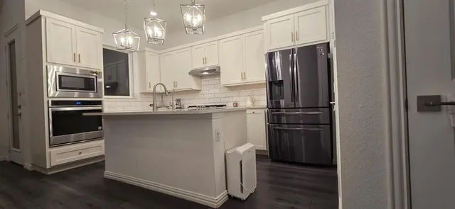 a kitchen with kitchen island wooden cabinets and stainless steel appliances