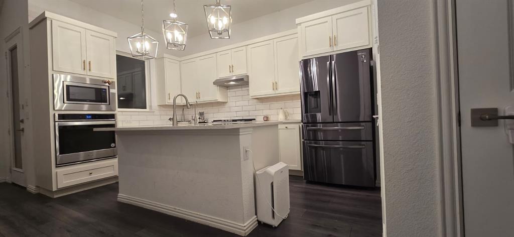 9807 Romo Street Irving, TX 75063 - Photo 7 of 8 a kitchen with kitchen island wooden cabinets and stainless steel appliances