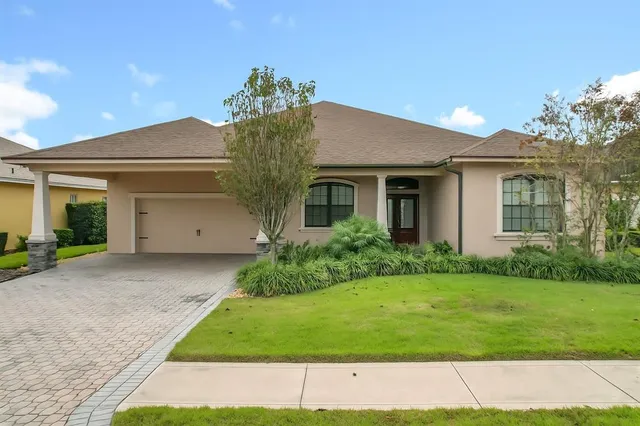 a front view of a house with a garden and yard