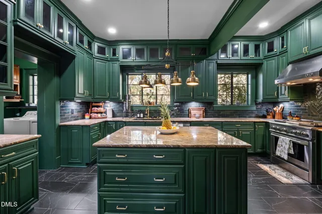 a kitchen with stainless steel appliances granite countertop a sink a stove and a microwave