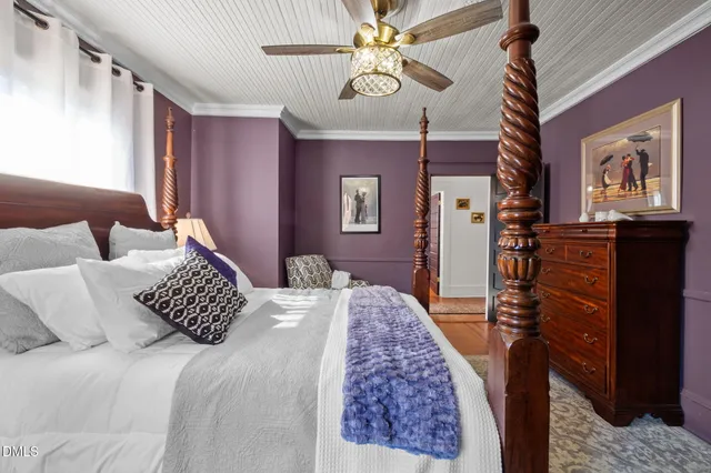 a view of a white house with large windows and a small yard