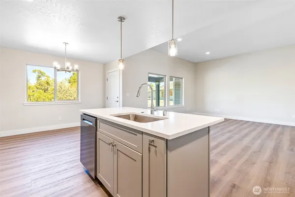 a kitchen with a sink a counter space and wooden floor