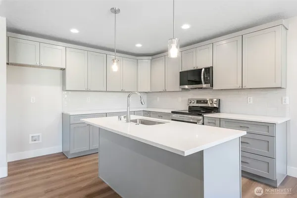 a kitchen with a sink a microwave a stove and refrigerator