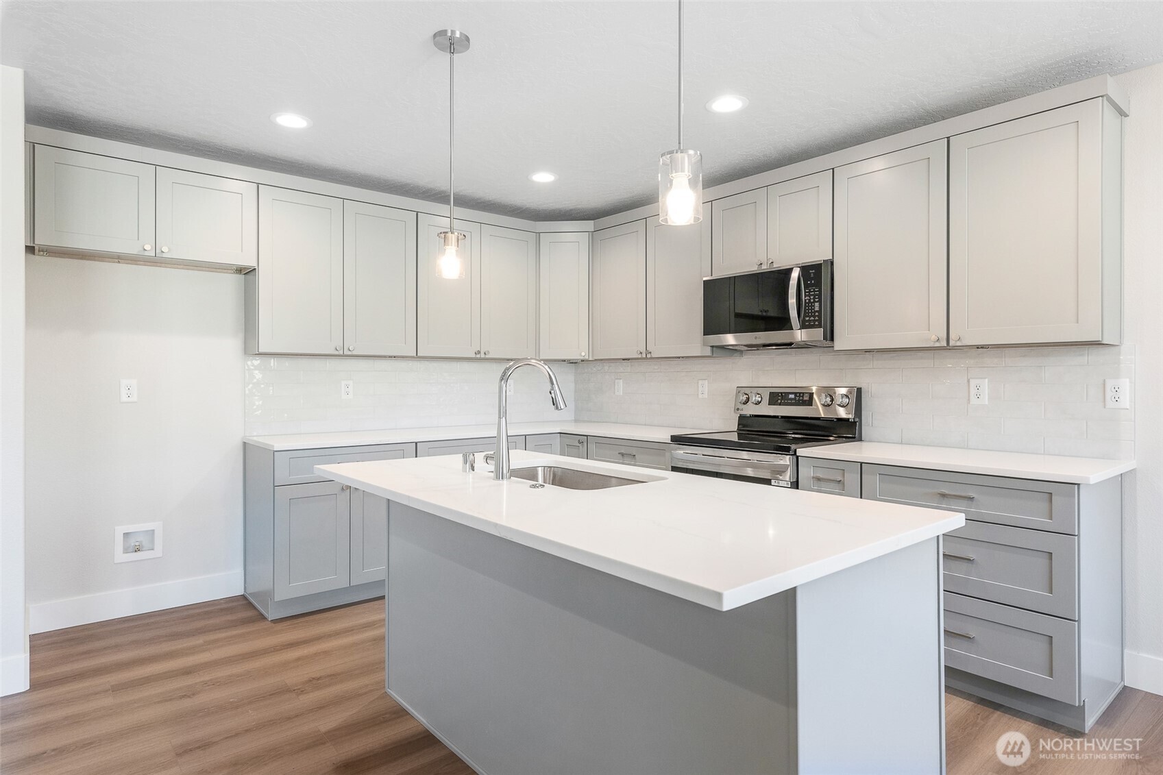 4246 Sandy Street Moses Lake, WA 98837 - Photo 9 of 29 a kitchen with a sink a microwave a stove and refrigerator