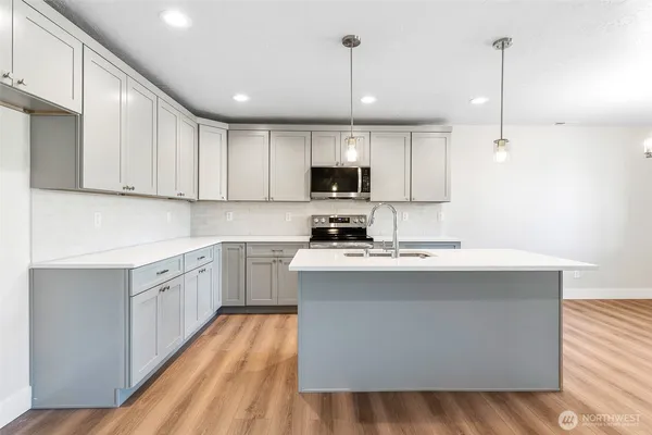a kitchen with stainless steel appliances granite countertop a sink stove and microwave
