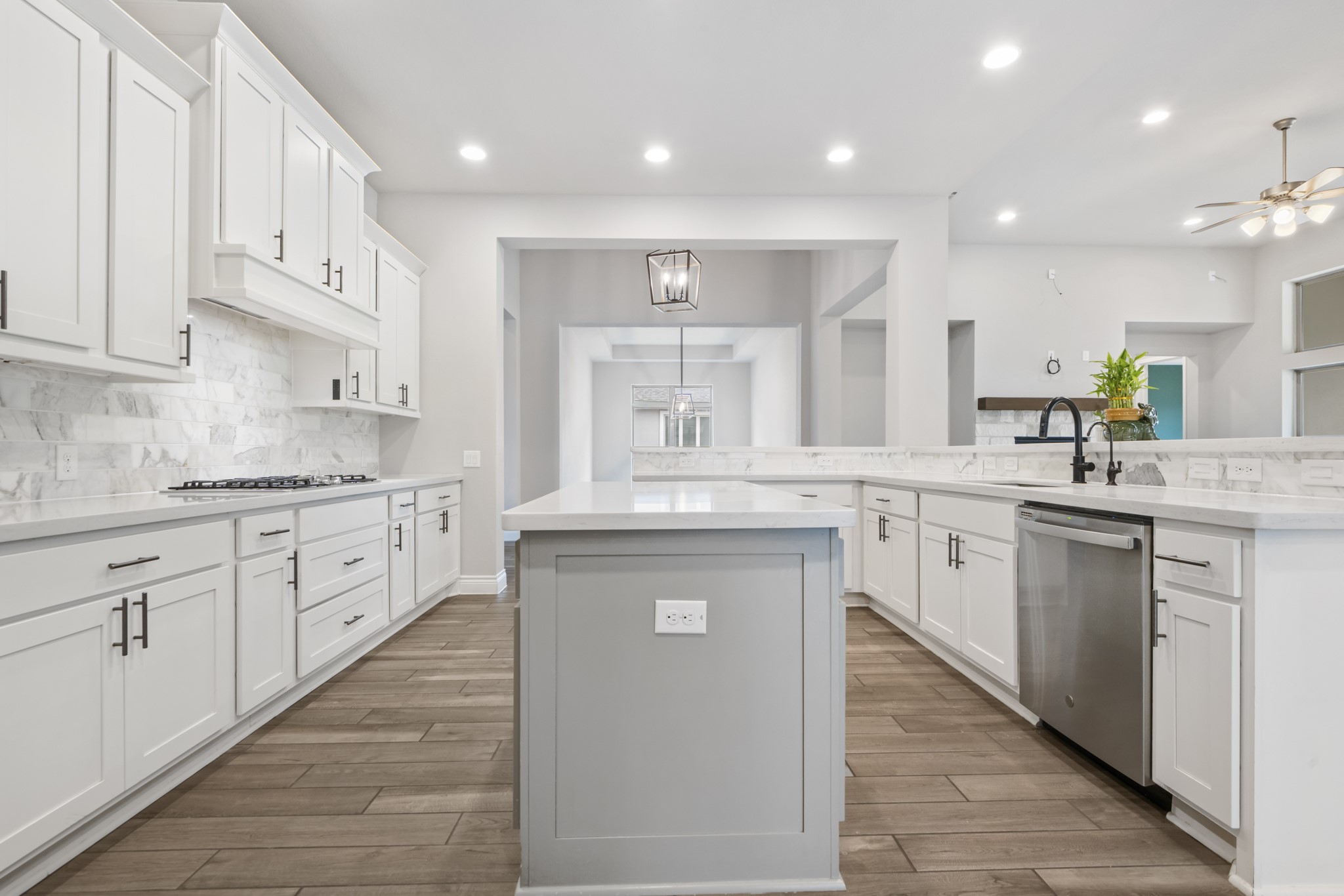 104 Catani Loop Georgetown, TX 78628 - Photo 29 of 34 Modern kitchen featuring white cabinetry, light countertops, a dark faucet, and wood-look flooring
