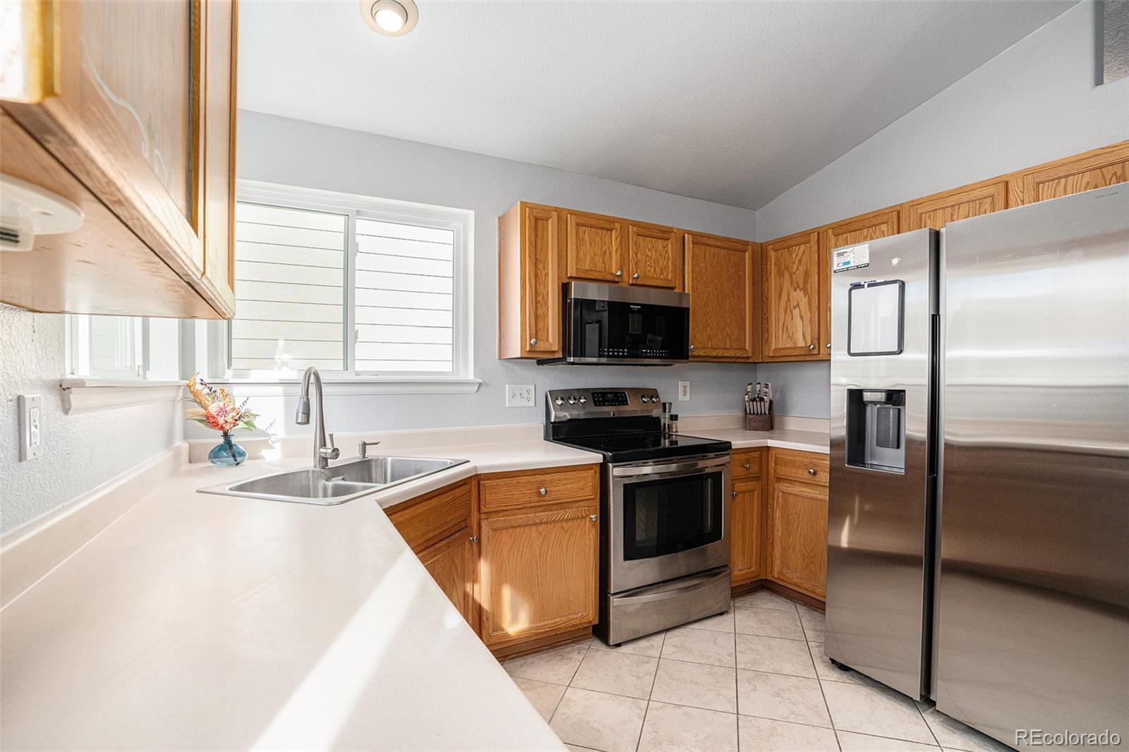 1085 Mockingbird Street Brighton, CO 80601 - Photo 3 of 21 a kitchen with stainless steel appliances granite countertop a sink stove and refrigerator