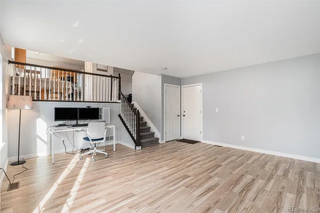 a view of a livingroom with wooden floor and staircase