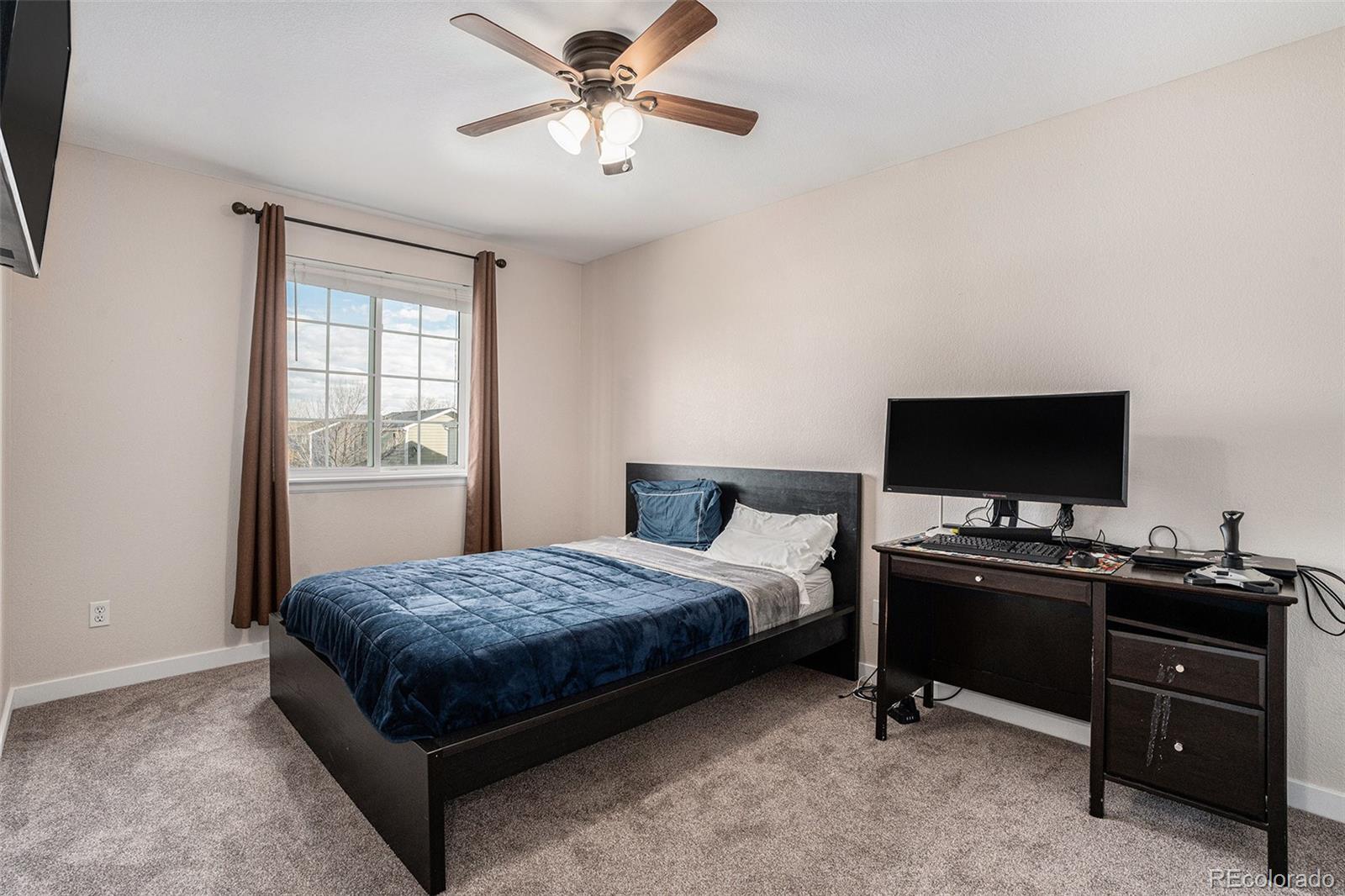 1085 Mockingbird Street Brighton, CO 80601 - Photo 10 of 21 a bedroom with a bed and a flat screen tv