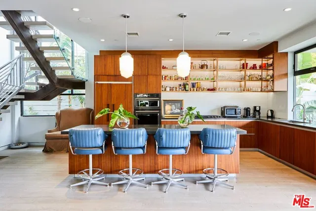 a room with stainless steel appliances kitchen island granite countertop furniture and a large window