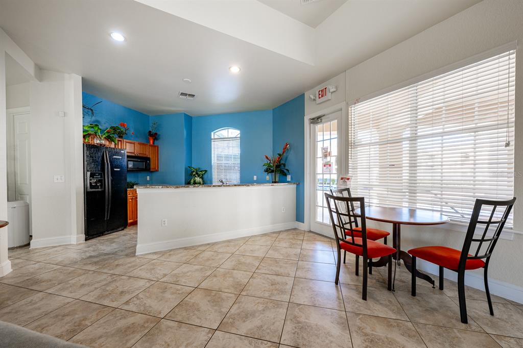 102 Terrace Ridge Circle, Unit 102 Davenport, FL 33896 - Photo 30 of 32 a view of a dining room with furniture and a large window
