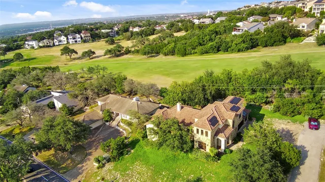 an aerial view of residential houses with outdoor space and trees