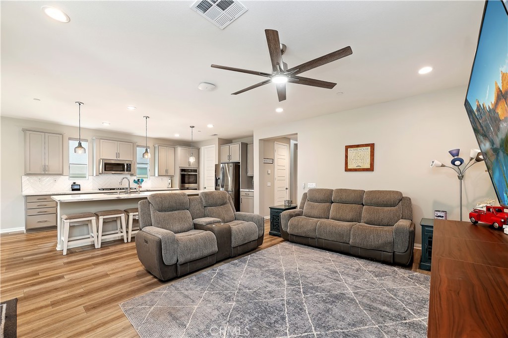 39526 Verbena Way Temecula, CA 92591 - Photo 25 of 55 a living room with furniture kitchen view and a wooden floor