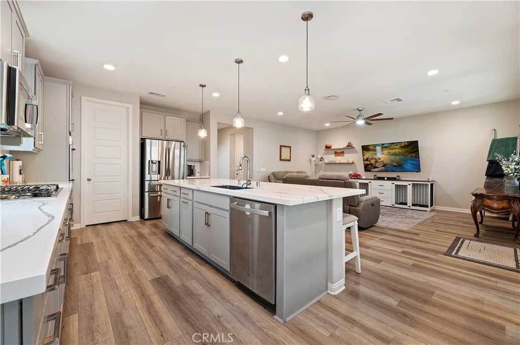 39526 Verbena Way Temecula, CA 92591 - Photo 6 of 55 a kitchen with stainless steel appliances kitchen island a large island in the center