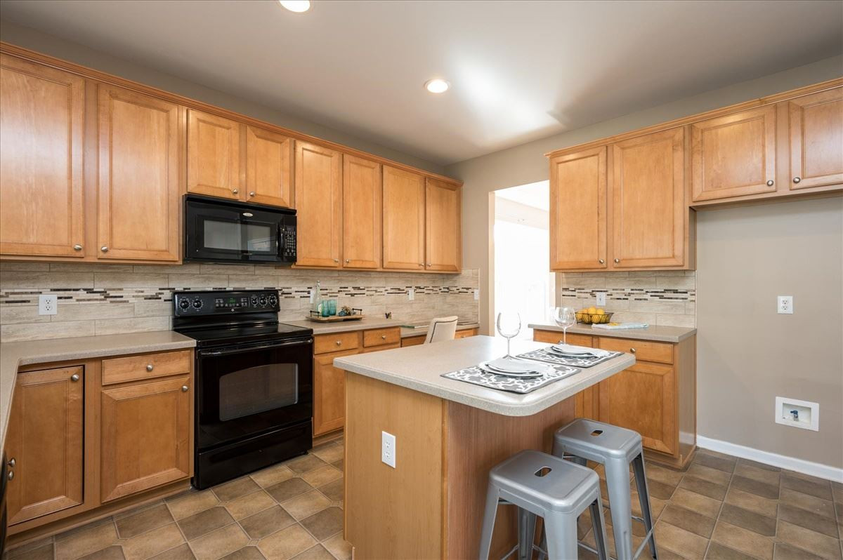 7810 San Gabriel Street Raleigh, NC 27613 - Photo 11 of 29 Kitchen features maple cabinets, solid surface countertops, tons of storage space and desk Kitchen