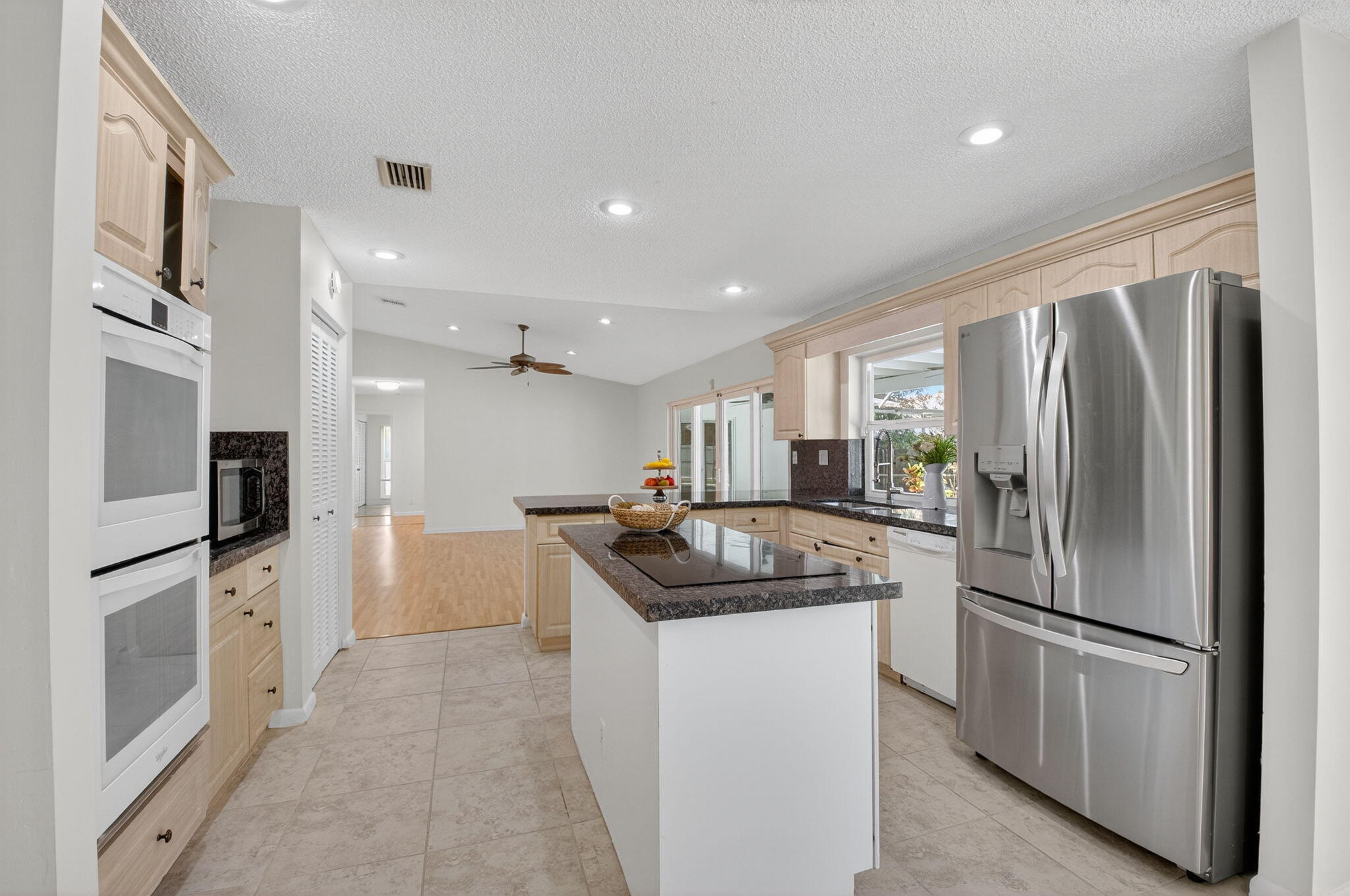 17414 Springtree Lane Boca Raton, FL 33487 - Photo 20 of 49 a kitchen with stainless steel appliances granite countertop a refrigerator a sink a stove and a refrigerator with wooden floor