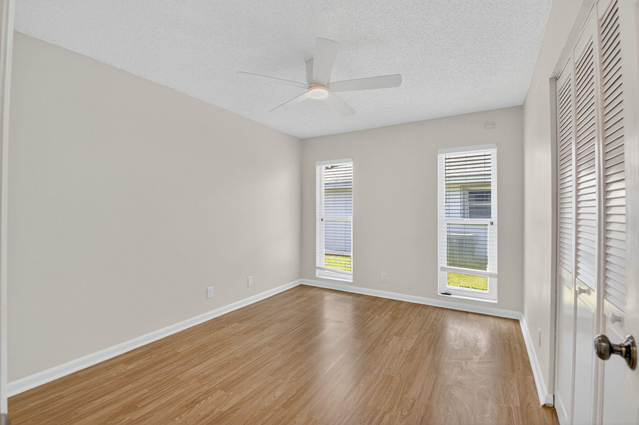 17414 Springtree Lane Boca Raton, FL 33487 - Photo 34 of 49 an empty room with wooden floor and windows