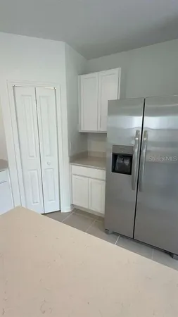 a kitchen with a refrigerator sink and cabinets