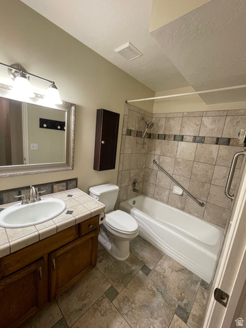 101 1501 Monroe, Unit 101 Ogden, UT 84404 - Photo 16 of 24 Bathroom with vanity, washtub / shower combination, and a textured ceiling