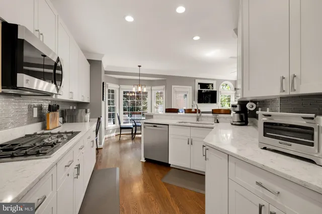 a kitchen with stainless steel appliances a stove sink microwave and cabinets