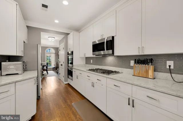 a kitchen with granite countertop a sink a stove and cabinets